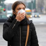 Woman walking down a city street wearing a face mask