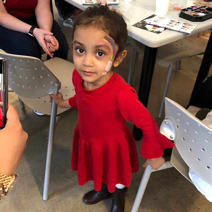 Little girl with a rainbow painted on her face for Bengali