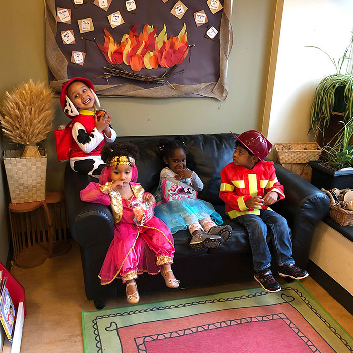 Four children dressed up as princesses and firemen