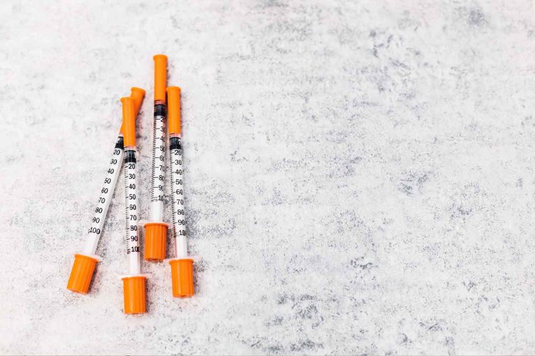 A group of orange capped syringes