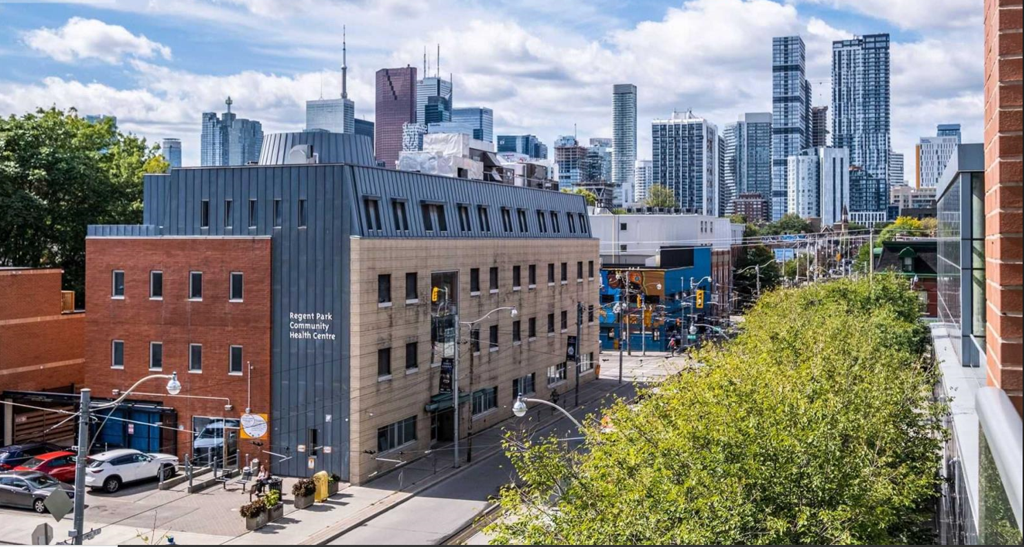 Exterior view of the Regent Park Community Health Centre building with the City of Toronto in the back